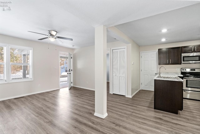 kitchen with dark brown cabinetry, sink, stainless steel appliances, and wood-type flooring