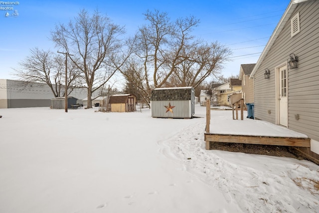 yard layered in snow with a storage unit