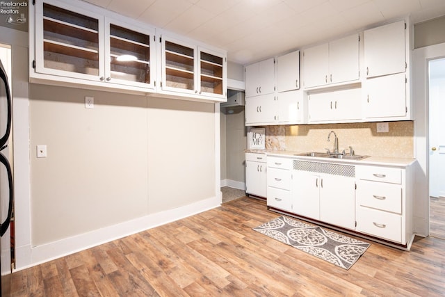 kitchen with white cabinetry, sink, and light hardwood / wood-style floors