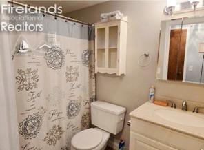 bathroom with a shower with curtain, vanity, and toilet