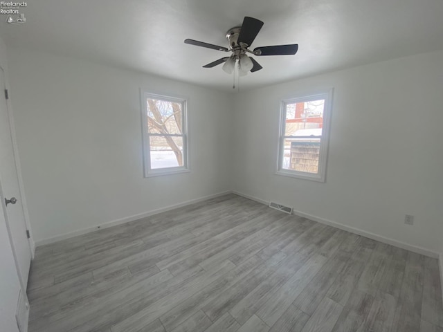 spare room with ceiling fan and light wood-type flooring