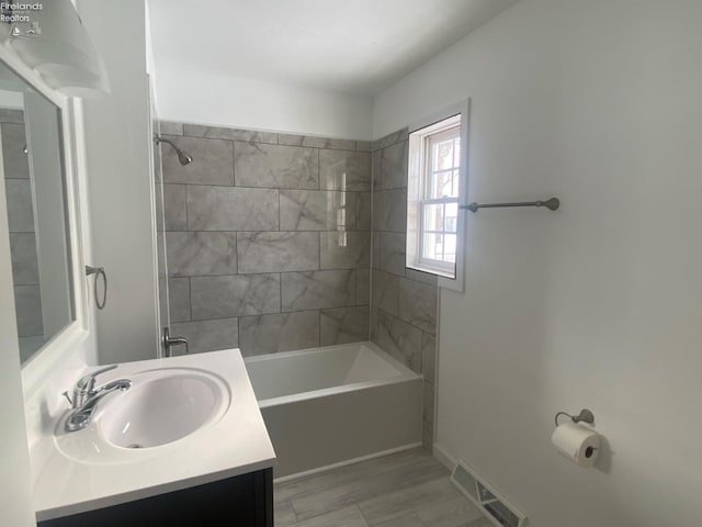 bathroom with vanity and tiled shower / bath combo