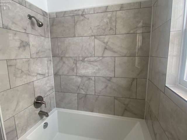 bathroom featuring tiled shower / bath