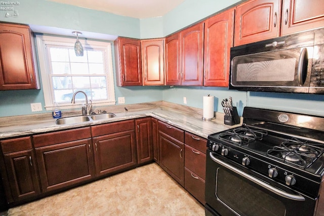 kitchen featuring light stone countertops, black appliances, and sink