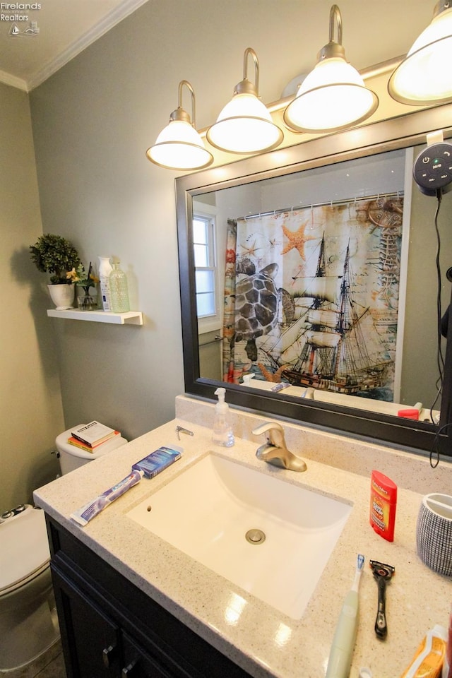 bathroom featuring ornamental molding, vanity, and toilet