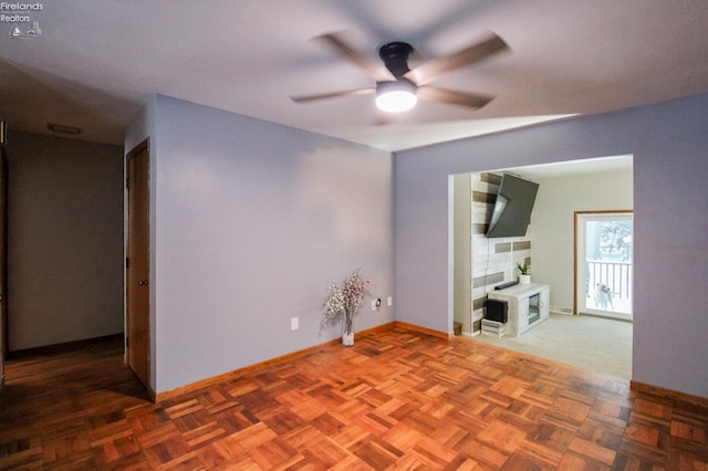 unfurnished room featuring ceiling fan and parquet flooring