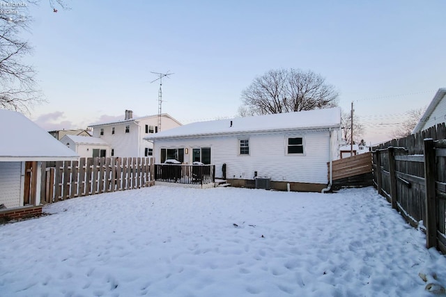 snow covered house featuring central AC unit