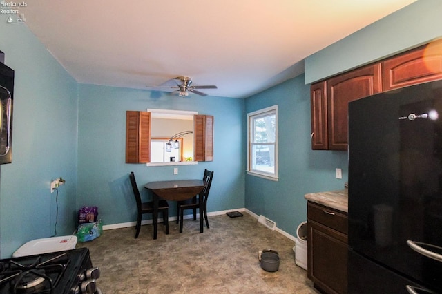 kitchen with stainless steel range, ceiling fan, and black refrigerator