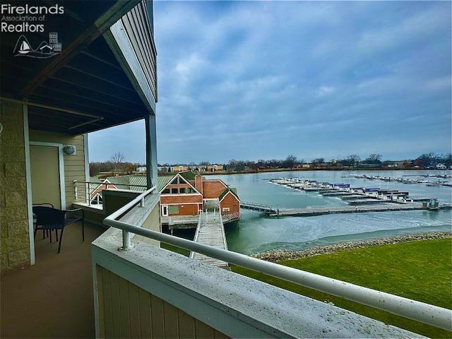 view of dock with a balcony and a water view