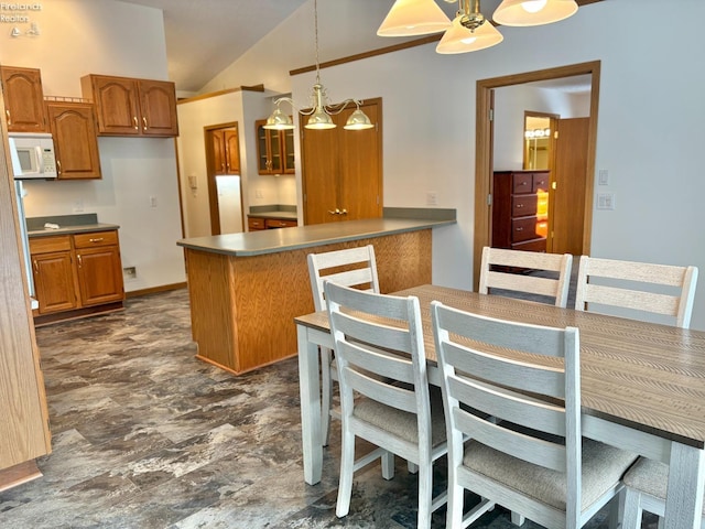 kitchen with pendant lighting, ceiling fan with notable chandelier, lofted ceiling, and kitchen peninsula