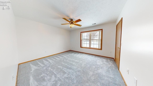 spare room featuring a textured ceiling, light carpet, and ceiling fan