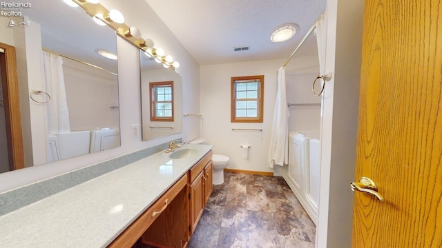 bathroom featuring curtained shower, vanity, and toilet