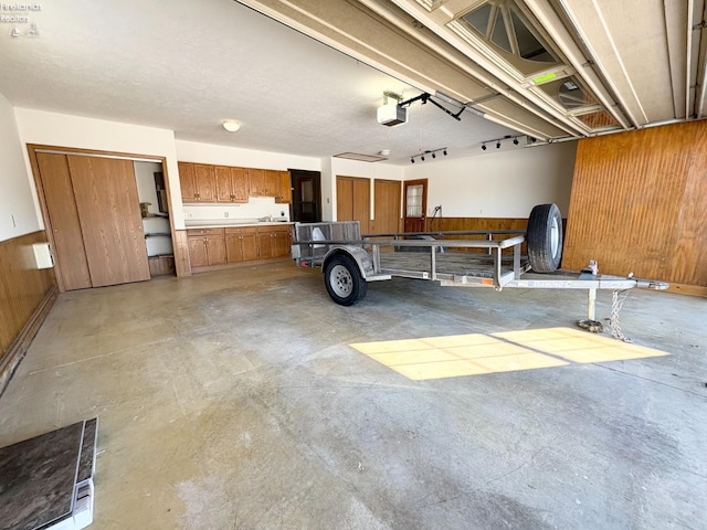 garage featuring wood walls and a garage door opener