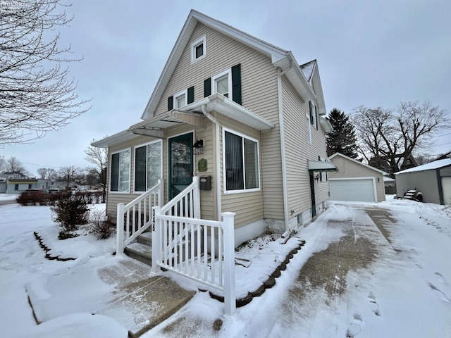 view of front of home with a garage and an outbuilding