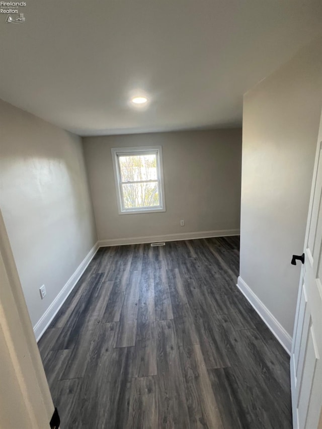 unfurnished room with dark hardwood / wood-style flooring