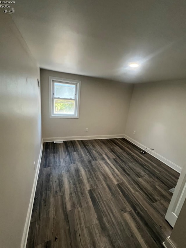 unfurnished room with dark hardwood / wood-style floors