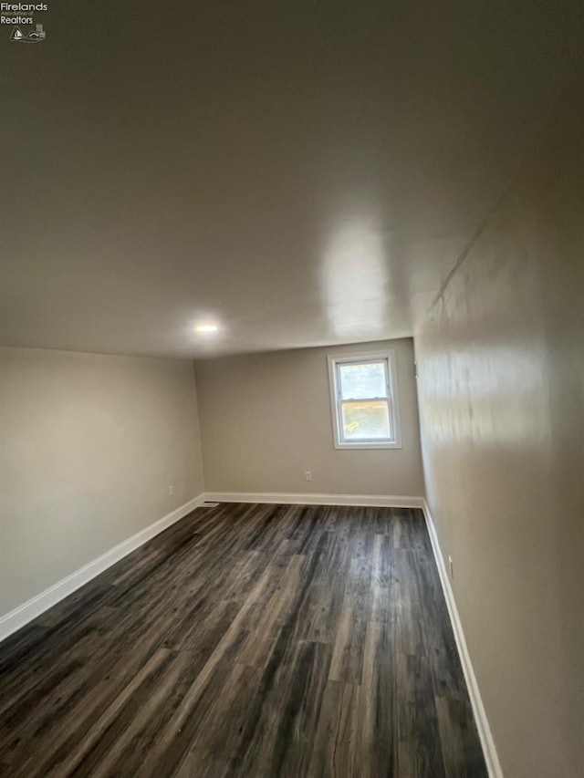 empty room with dark hardwood / wood-style flooring