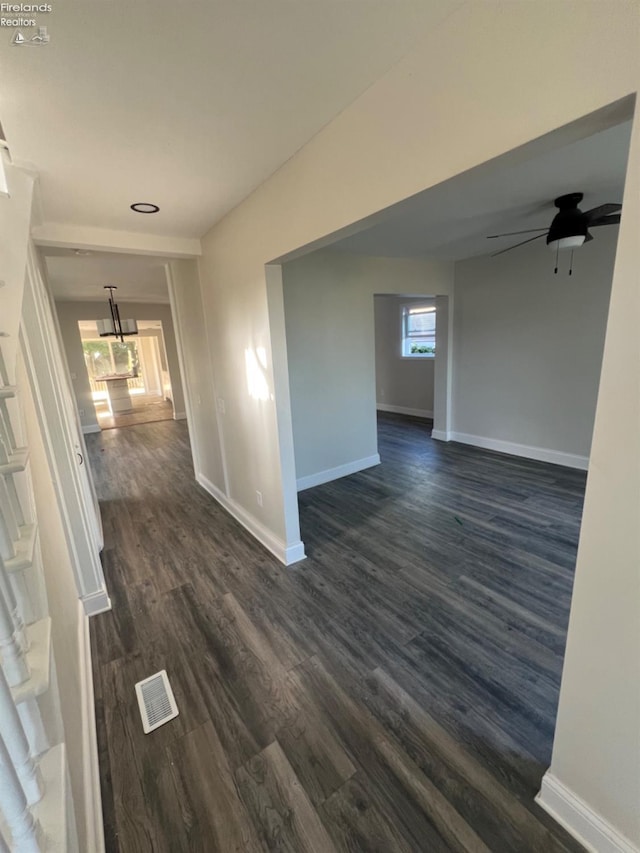 unfurnished room with ceiling fan, dark wood-type flooring, and plenty of natural light