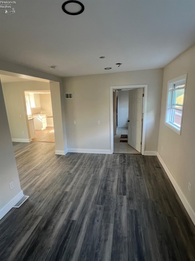 empty room with dark hardwood / wood-style flooring