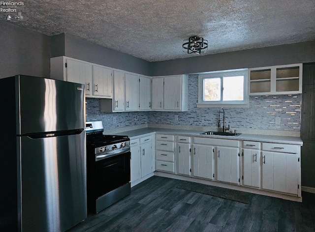 kitchen with white cabinets, appliances with stainless steel finishes, sink, backsplash, and dark hardwood / wood-style floors