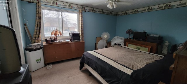 bedroom featuring a textured ceiling, ceiling fan, and light colored carpet