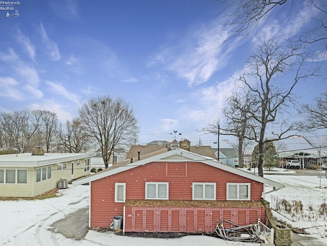 view of snowy exterior with cooling unit