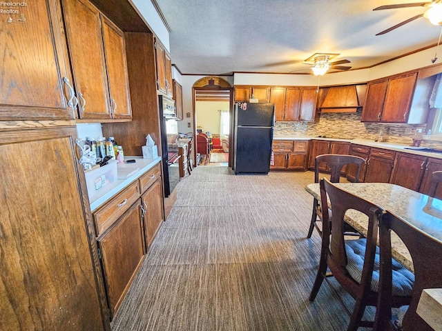 kitchen featuring carpet, black appliances, premium range hood, backsplash, and ceiling fan