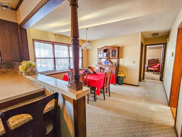 carpeted dining space with a textured ceiling