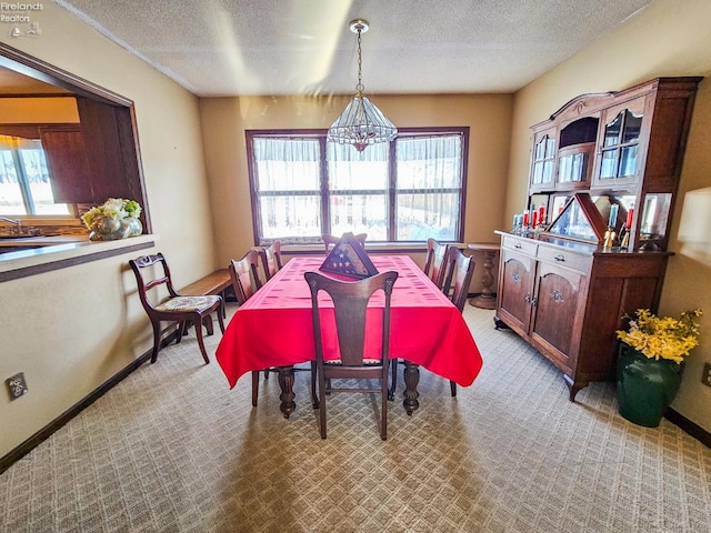 carpeted dining area with a textured ceiling and a notable chandelier