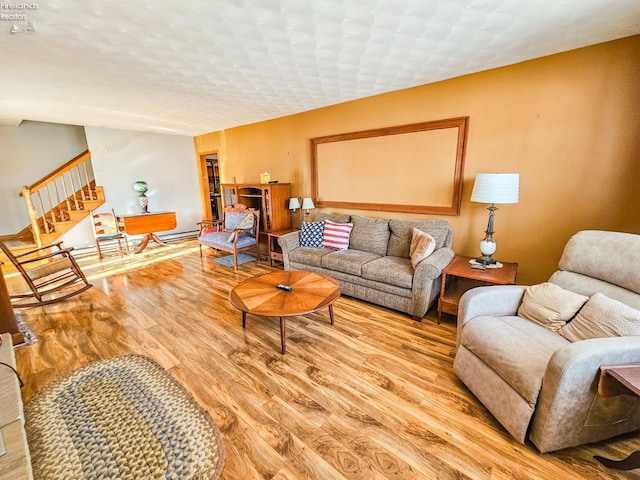 living room with light wood-type flooring, a textured ceiling, and a baseboard radiator