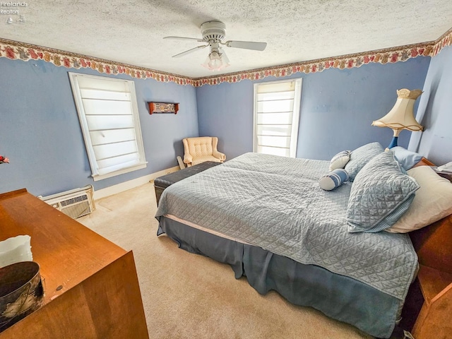 carpeted bedroom featuring a textured ceiling, ceiling fan, and an AC wall unit