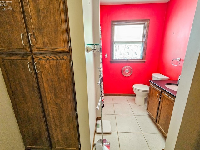 bathroom with toilet, vanity, and tile patterned flooring