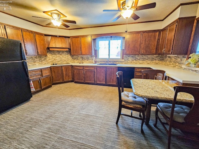 kitchen with black appliances, crown molding, sink, and premium range hood