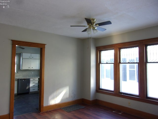 empty room with ceiling fan and dark hardwood / wood-style flooring