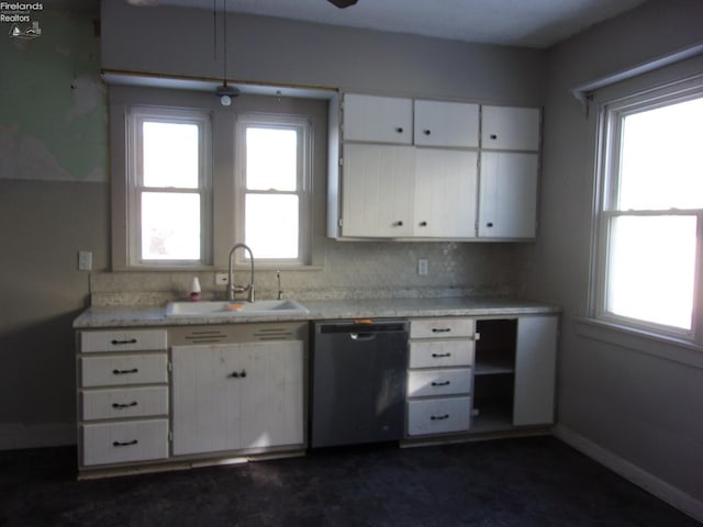 kitchen with a wealth of natural light, white cabinetry, dishwasher, and sink