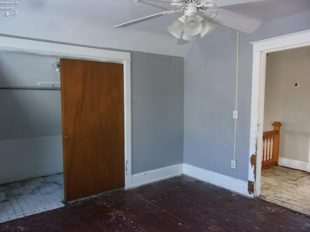 unfurnished bedroom with ceiling fan, a closet, dark hardwood / wood-style flooring, and lofted ceiling