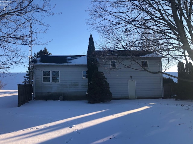 view of snow covered back of property