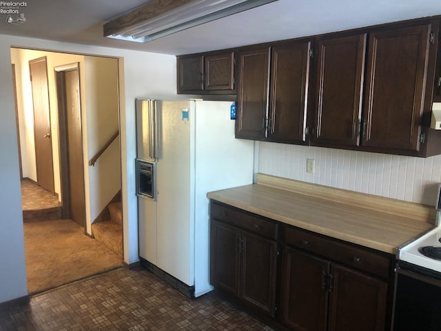 kitchen featuring backsplash, electric range, white fridge with ice dispenser, wall chimney range hood, and dark brown cabinetry