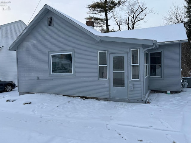 view of snow covered back of property