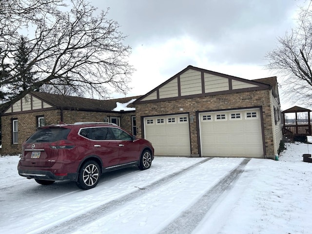 view of snowy exterior with a garage