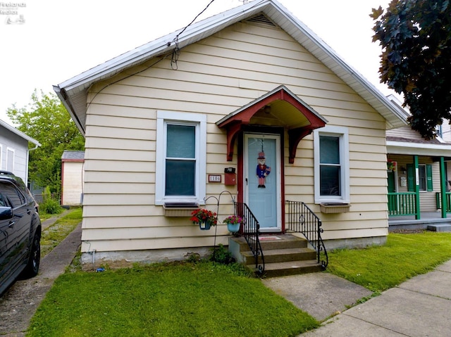 bungalow featuring a front lawn