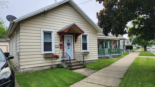 bungalow-style home with a front yard