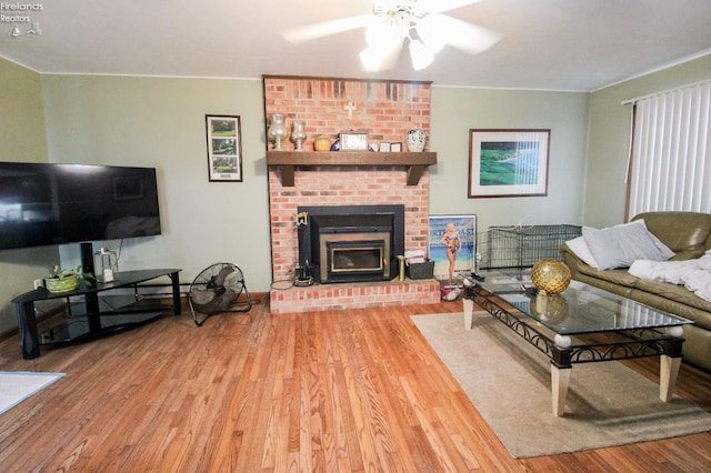 living room with ceiling fan, a brick fireplace, and hardwood / wood-style flooring