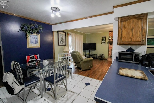 tiled dining space featuring a textured ceiling and crown molding