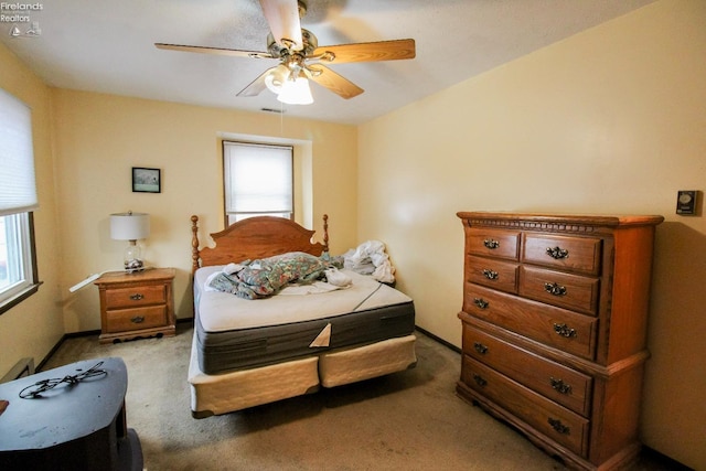 carpeted bedroom with ceiling fan and multiple windows