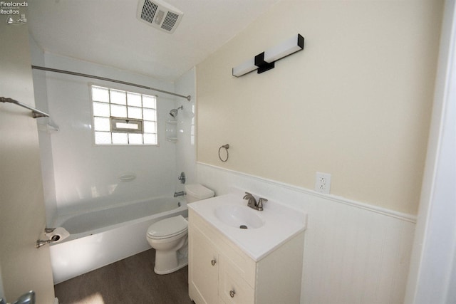 full bathroom with hardwood / wood-style flooring, toilet, vanity, and tiled shower / bath combo