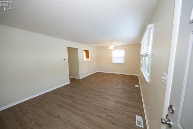 empty room with ceiling fan and dark hardwood / wood-style floors