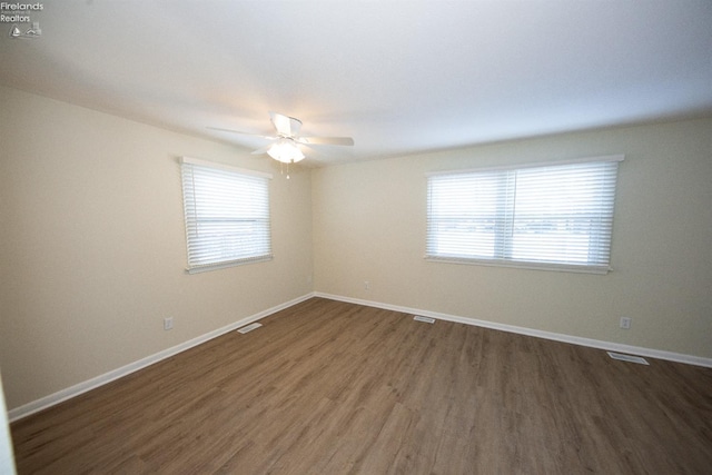 spare room featuring ceiling fan and dark hardwood / wood-style floors