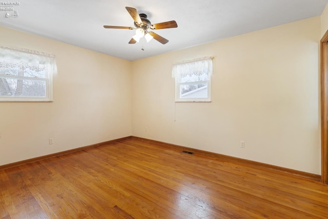 empty room with hardwood / wood-style flooring and ceiling fan