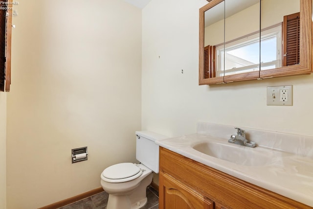 bathroom with toilet, vanity, and tile patterned floors